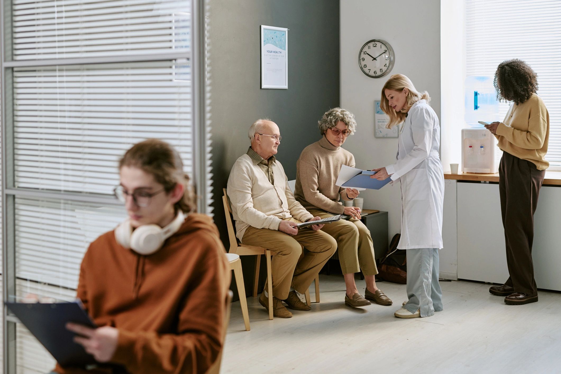 Modern healthcare facility waiting area with patients and staff